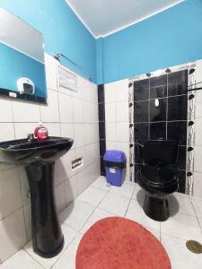 利马Samay Wasi - Aeropuerto的浴室设有黑色的卫生间和水槽。