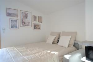 克吕塞耶STUDIO dernier étage avec terrasse - vue montagne的墙上挂着照片的房间的白色沙发