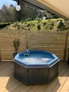 ArfordBeauslodge Authentic Log Cabin With Private Hot Tub的木制甲板上的大型热水浴池