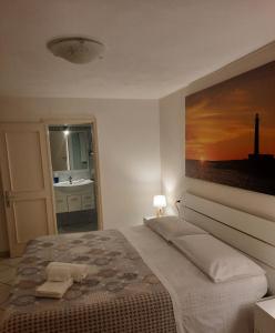 法维尼亚纳Villa Oblò的卧室配有一张床,墙上挂有绘画作品