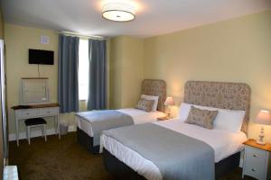 克朗梅尔贝法尼地中海餐厅及联排别墅酒店的酒店客房设有两张床和电视。