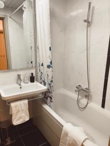 波德戈里察Aurora Apartment的白色的浴室设有水槽和浴缸。