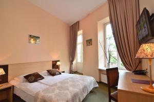 维尔纽斯伊沃利塔维尔纽斯酒店的一间卧室配有一张床、一张书桌和窗户。