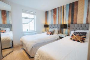 伦敦美丽的中心六人家庭公寓的一间卧室设有两张床和窗户。