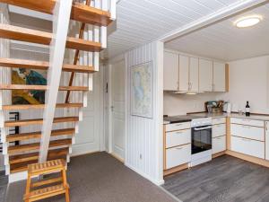 海默特6 person holiday home in Hemmet的厨房配有白色橱柜和螺旋楼梯