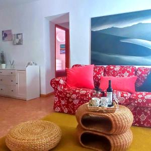 弗龙特拉Casa Nela. Rural y acogedora en Las Puntas El Hierro的客厅配有红色的沙发和桌子