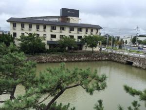 唐津庄内酒店的建筑物前有河流的建筑物