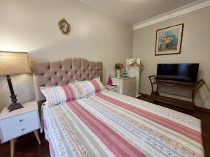 利马Casa Amarello的一间卧室配有一张床和一台平面电视
