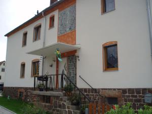 Gemünden an der WohraTiny-Apartment-in-Gemuenden-an-der-Wohra的白色的房子,前面有楼梯