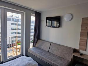 汉堡梅塞德斯中心酒店的一间带沙发、电视和窗户的卧室