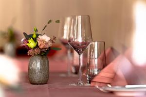 迈伦迈伦特迪亚努姆公寓的一张桌子,上面放着两杯葡萄酒和花瓶