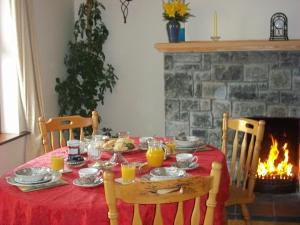 里南山景住宿加早餐旅馆的一张桌子,上面有红色桌布和一个壁炉