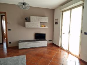 比耶拉Appartamento con vista montagne的带电视的客厅和瓷砖地板。