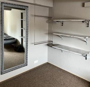 费马恩Hostel Fehmarn Mehrbett-Zimmer的步入式衣柜,配有镜子和床