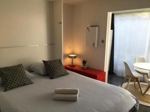 拉格朗德默特Le Ponant, Wifi, Piscine, Parking的一间卧室配有一张带两个枕头和一张桌子的床。