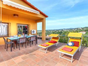 马斯萨内特德拉塞尔瓦VILLA BLANCA 10 minutos de la Playa Costa brava的一个带桌椅的庭院和一个阳台