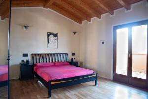 利莫内-苏尔加达Guesthouse "Villa Tamas"的一间卧室配有一张带粉色床单的床和一扇窗户。