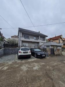 索科矿泉村Apartman Boskovic的两辆汽车停在房子前面的停车场