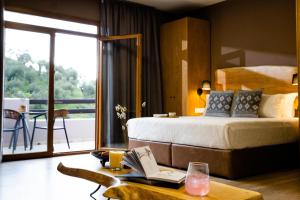 梅加利阿莫斯Skiathos Avaton Suites & Villas, Philian Hotels and Resorts的酒店客房,配有一张床和一张桌子,还有一本书