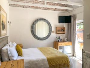大布拉克勒菲Seeplaas Guesthouse的卧室配有一张床,墙上设有镜子
