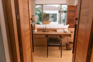 邦涛海滩Villa Alanna Phuket的客房设有带水槽和椅子的书桌。