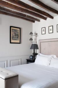 巴黎Hotel Saint-Louis en L'Isle - Notre-Dame的卧室配有白色的床和桌子