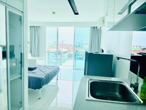 芭堤雅市中心City Center Residence Condominium Pattaya RJ的一个带水槽的厨房和一张位于客房内的床
