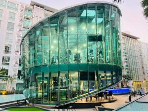 芭堤雅市中心City Center Residence Condominium Pattaya RJ的建筑前的玻璃建筑