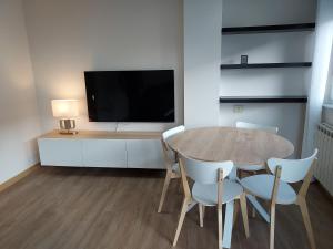 卢戈Apartamento Calzada Romana的一间带桌椅和电视的用餐室
