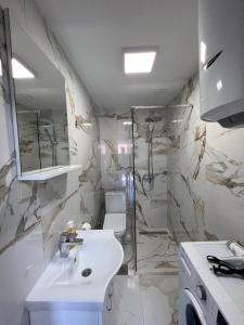 蒂瓦特Venice Apartments的白色的浴室设有水槽和淋浴。