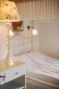 Store HeddingeStevns Klint Bed & Breakfast的卧室配有一张白色床和一张桌子上的台灯