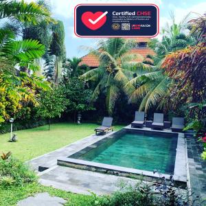 乌布Pondok Naya - CHSE Certified的花园内带两把椅子的游泳池