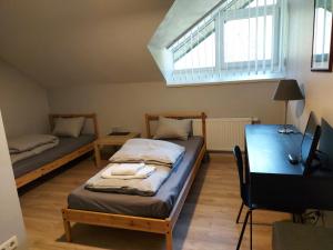 Rumšiškės,,Įlanka"的客房设有两张床、一张桌子和一个窗户。