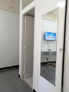 蒙巴萨Golden Nest的通向一间墙上配有电视的房间的开放式门