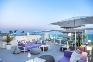 利多迪耶索罗J44 Lifestyle Hotel的一个带紫色家具、桌子和遮阳伞的庭院