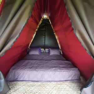 吉安雅Batan Nyuh Retreat的红色绿色帐篷内的一张床位