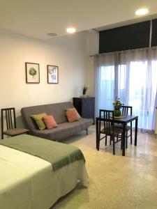 马拉加Apartamento con piscina en Ciudad Jardín的客厅配有沙发和桌子
