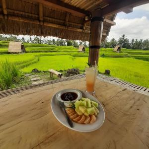 吉安雅Batan Nyuh Retreat的桌上的一盘食物,加上一杯果汁