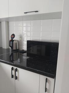 塔拉兹2-х комнатная квартира的厨房配有微波炉和黑色台面
