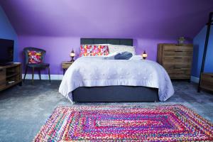 达尔比蒂The Art Bank的紫色卧室配有一张床和地毯