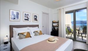 利吉亚ALMYRA seafront residence的一间卧室,配有一张床,上面有帽子