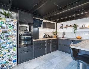 特鲁瓦Loft avec jardin et parking privé的厨房配有灰色橱柜和台面
