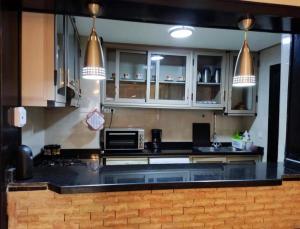 阿加迪尔MARINA AGADIR的厨房配有白色橱柜和黑色台面