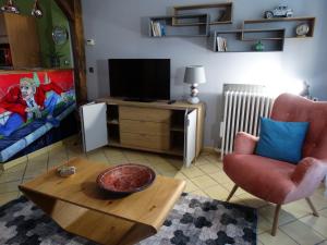 布尔日APPARTEMENTY COCO BOLO的客厅配有电视、椅子和桌子