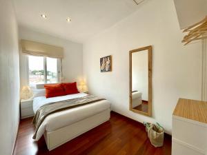 卡内·德·玛尔APARTAMENT MEDITERRANI的一间卧室配有一张带红色枕头和镜子的床
