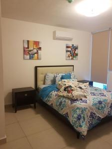 里奥阿托Alquiler de Apartamento en Playa Blanca的一间卧室配有一张带被子和桌子的床