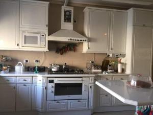 瓦迪穆萨Petra Villa的厨房配有白色橱柜和炉灶烤箱。