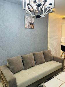 撒马尔罕Yas Apartment的客厅的沙发,配有吊灯