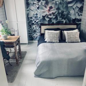 阿姆斯特丹Houseboat Bonnie的一间卧室设有一张床和鲜花墙