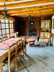 埃斯克尔Cabaña en la costa del Lago Futalaufquen - Parque Nacional Los Alerces的一间带桌子和壁炉的用餐室